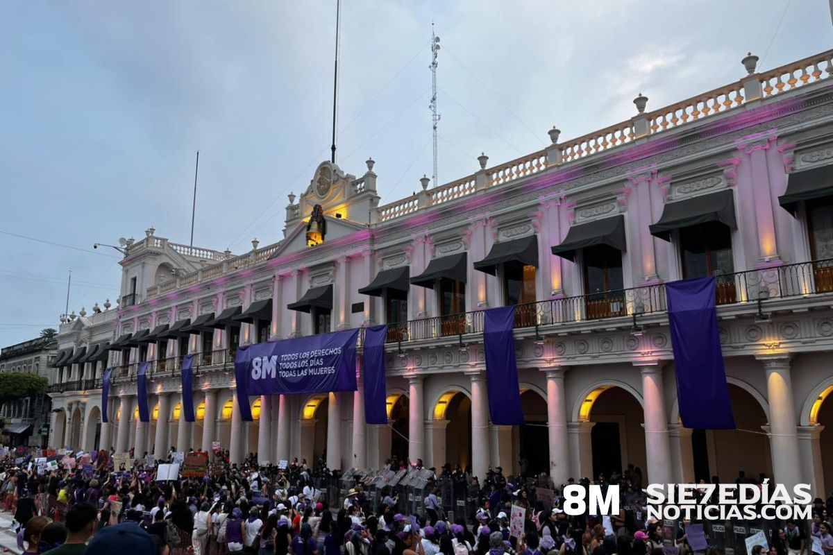 Marcha del 8M frente al Palacio de Gobierno en Xalapa con manifestantes y valla de policías estatales.