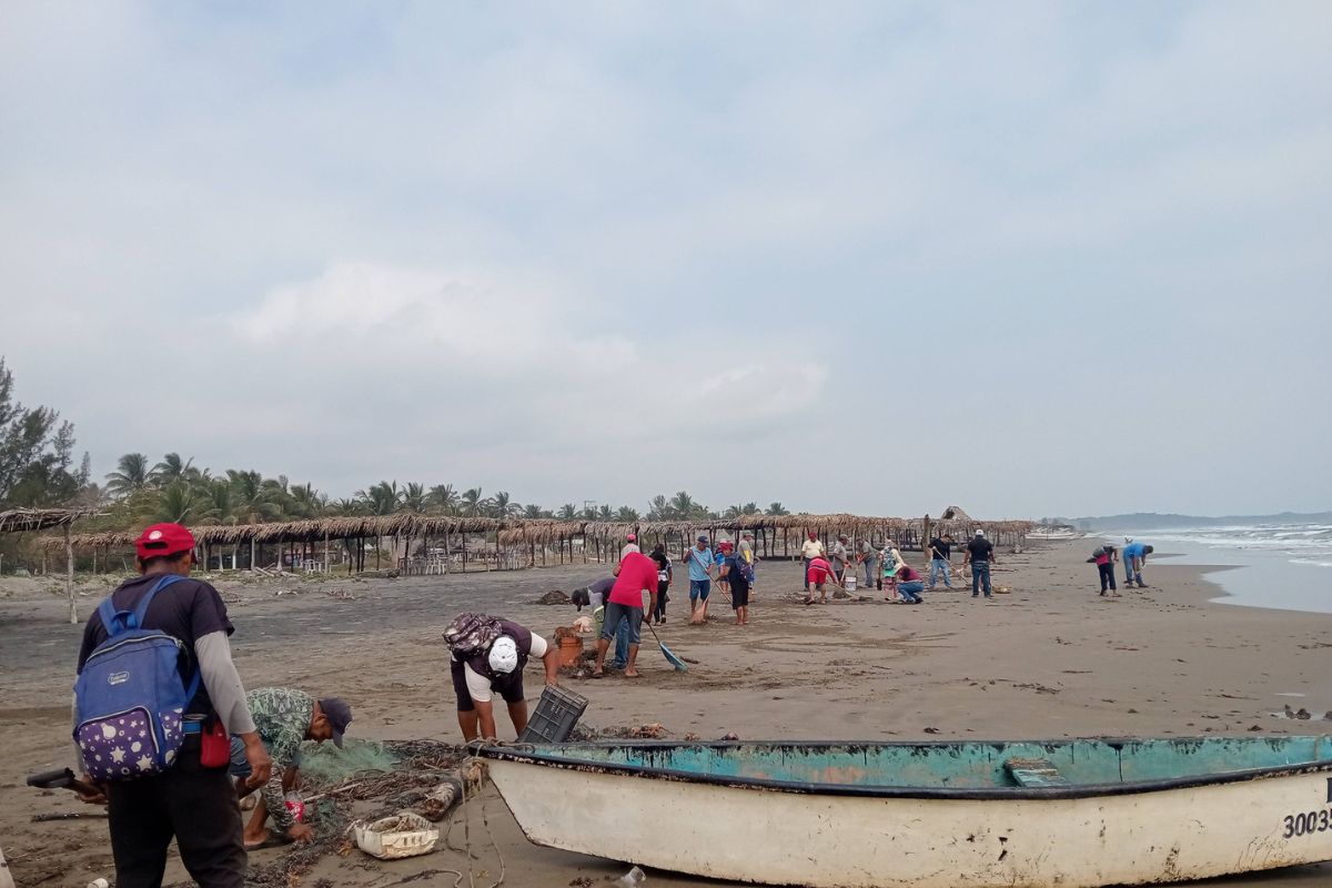 Habitantes limpian chapopote en playas de Veracruz sin equipo de protección durante derrame petrolero.