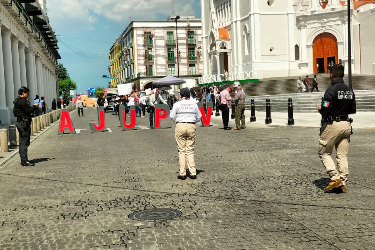 Jubilados del ISSSTE protestando y bloqueando calle Enríquez en Xalapa por falta de pago de seguros