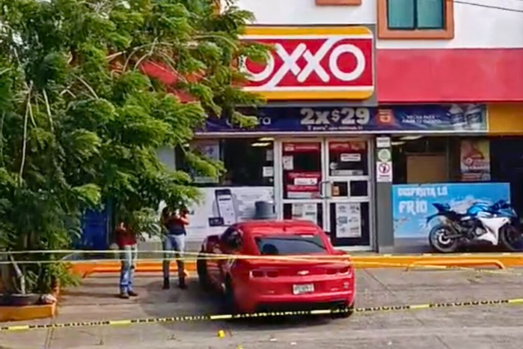 Camaro rojo acordonado por autoridades tras ataque armado frente al Oxxo de Petrópolis, en Tuxpan.