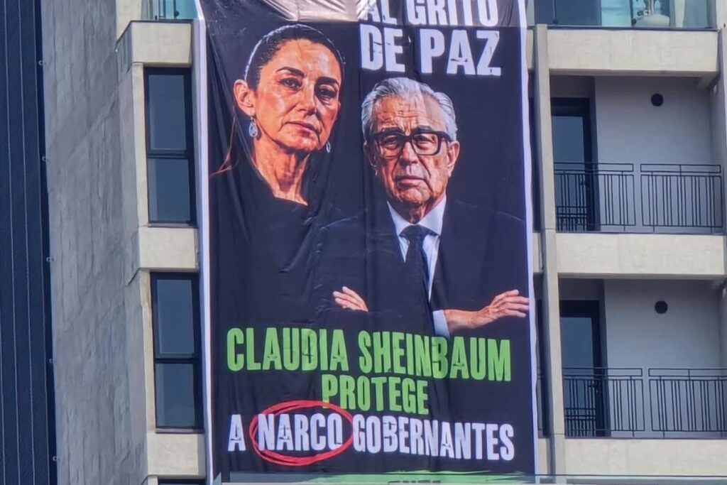Lona con imágenes de Claudia Sheinbaum y Rubén Rocha Moya desplegada desde un edificio cercano al Monumento a la Revolución durante un acto de Morena.