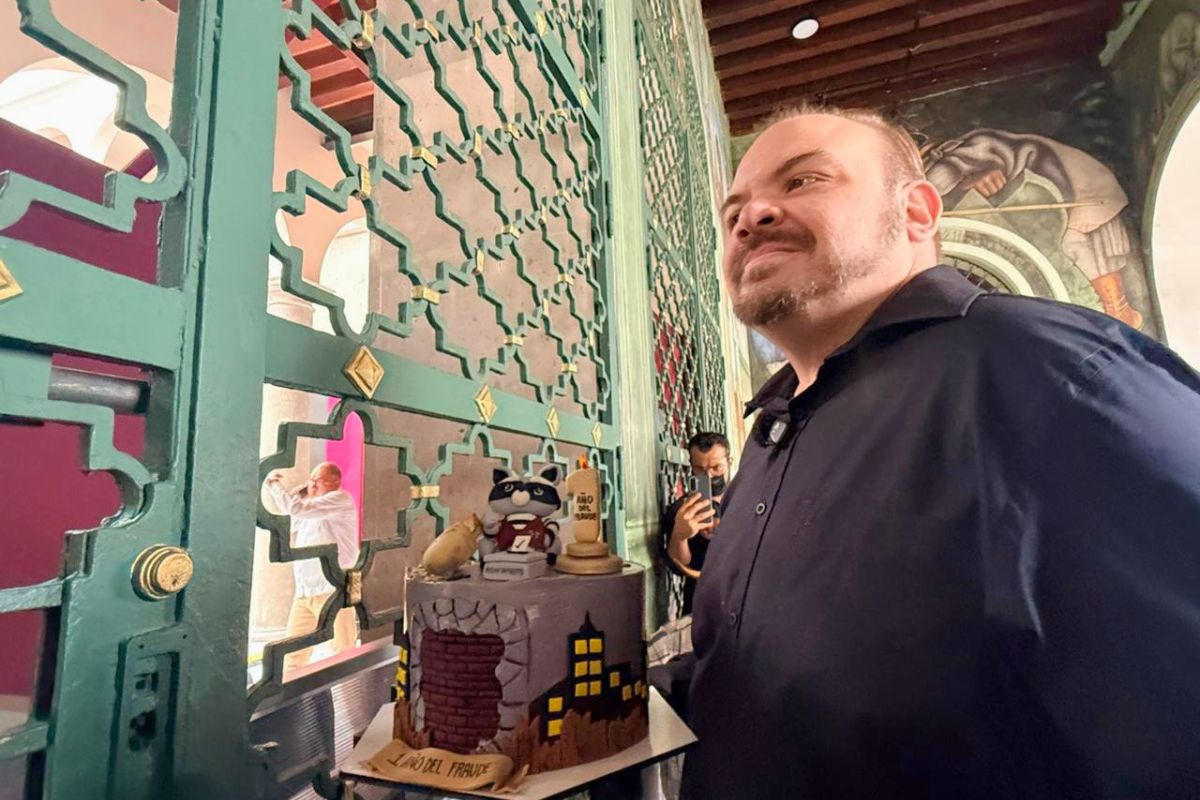 Sergio Gil Rullán muestra un pastel frente a Palacio de Gobierno durante una protesta por las elecciones de Poza Rica y Papantla.