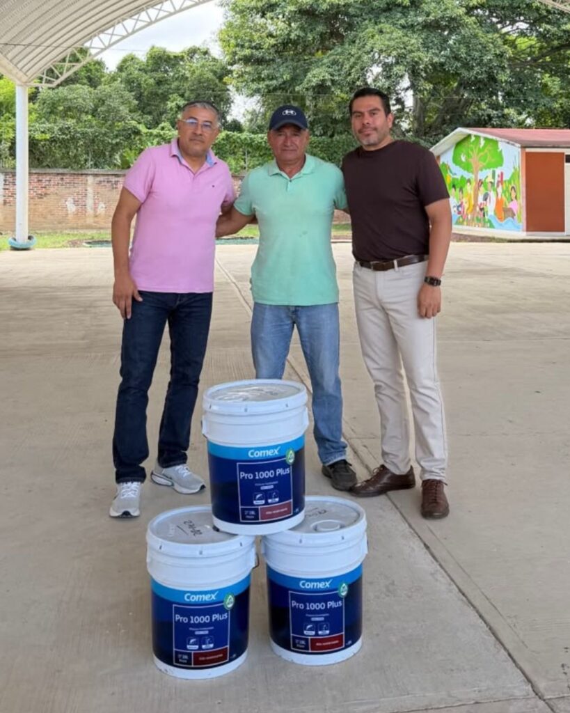 El diputado Diego Castañeda Aburto posa junto a directivos de una escuela de El Tronconal con tres cubetas de pintura Comex.
