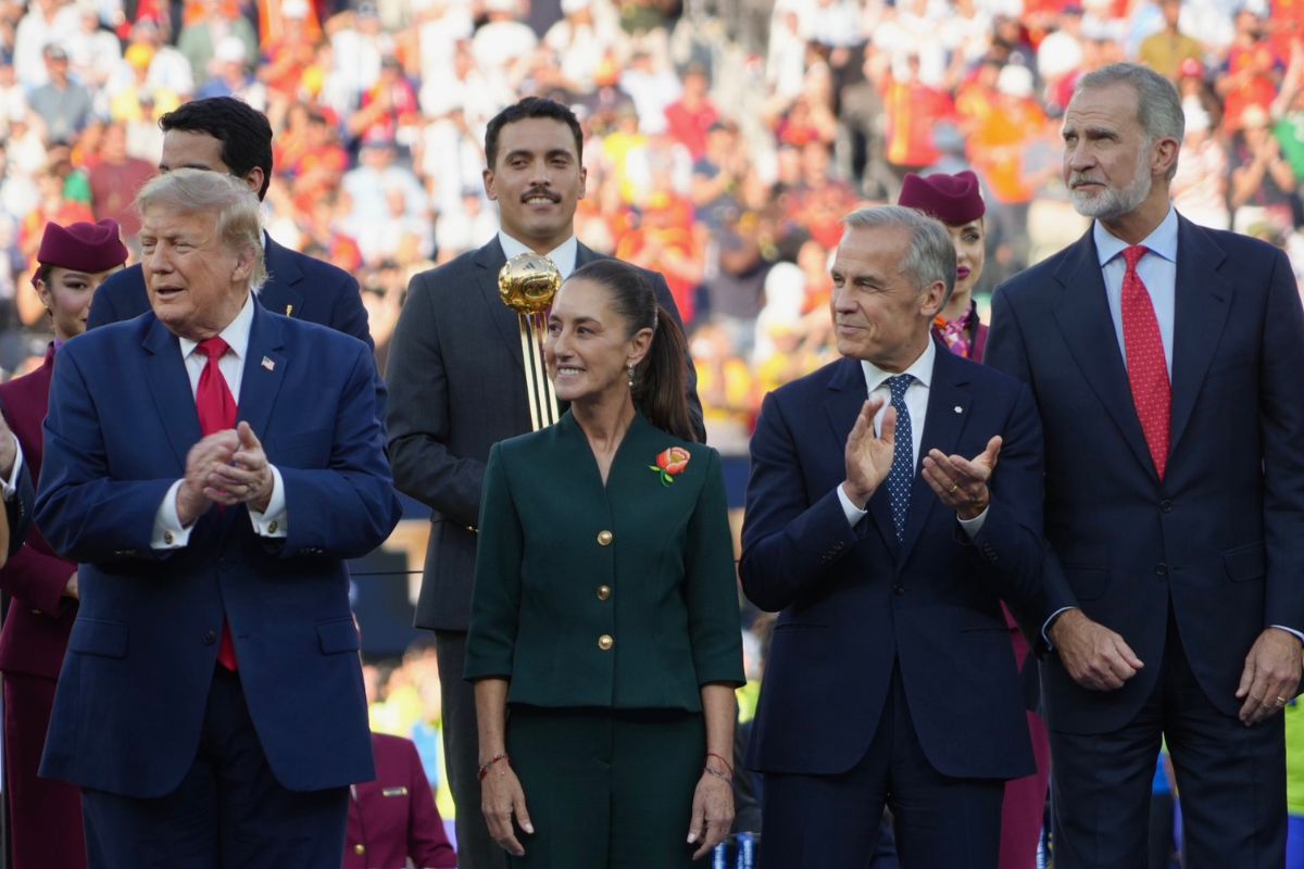 Claudia Sheinbaum porta una rosa roja en la solapa de su atuendo durante un acto oficial, símbolo de identidad política y reconocimiento a las artesanas mexicanas.