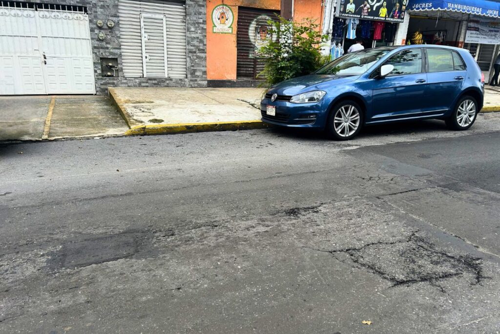 Trabajos de bacheo con mezcla asfáltica en una calle de Xalapa.