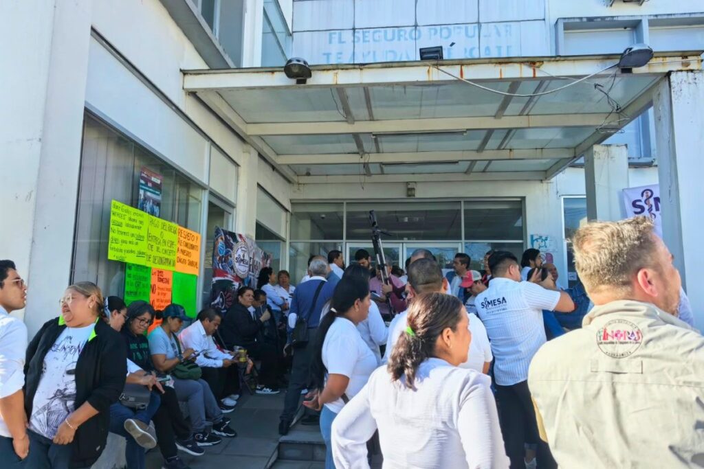 Trabajadores de IMSS-Bienestar en plantón frente a la Coordinación Estatal en Xalapa, con carteles y lonas sindicales.